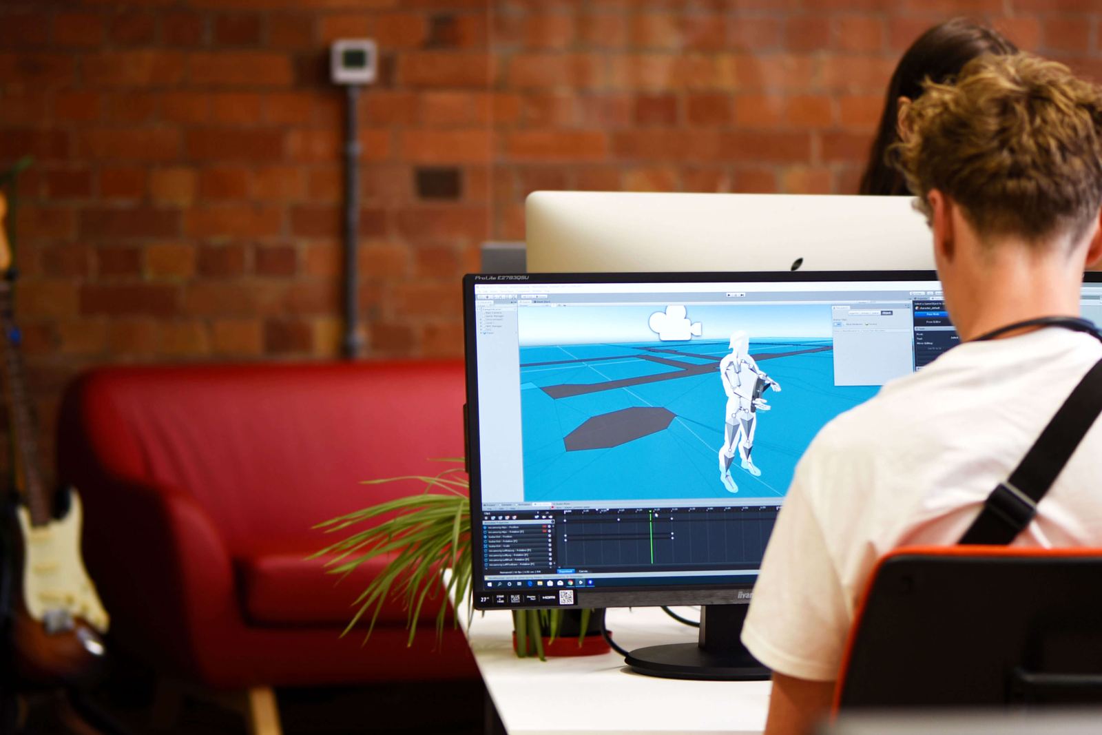 A designer working on a 3D model on a desktop monitor in the Transpose office